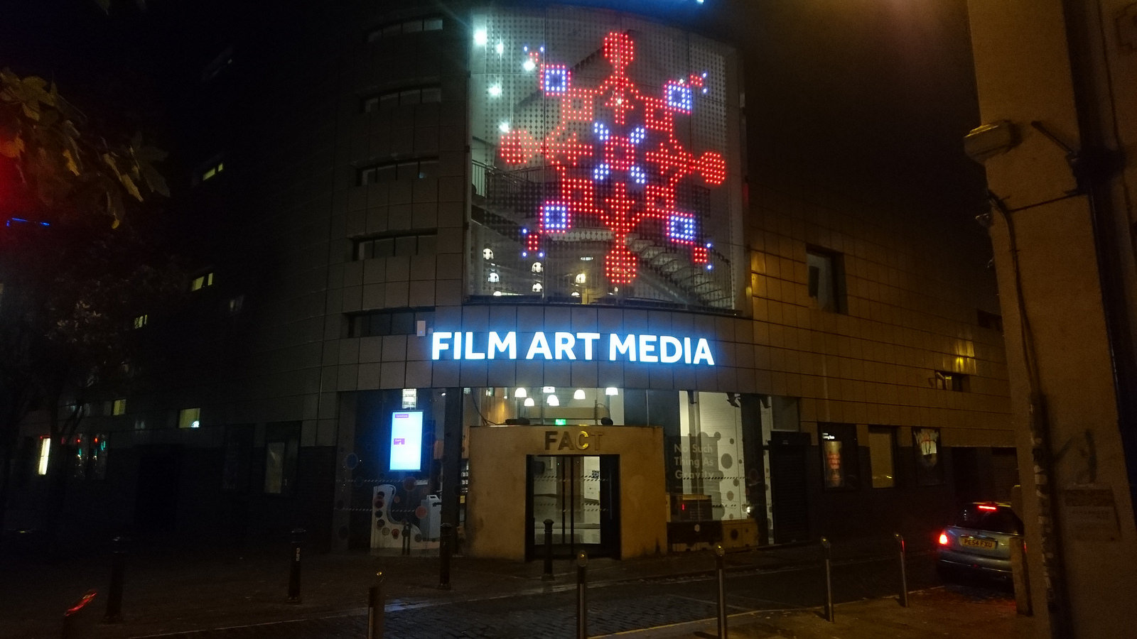 A photo of the LED facade at FACT showing one of the snowflakes in red